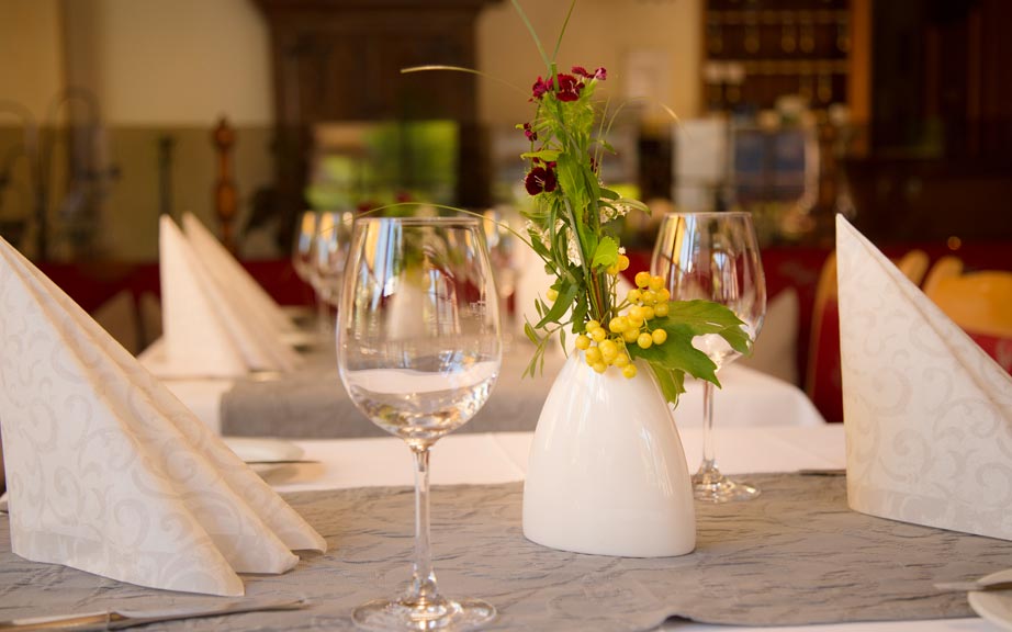 Festlich gedeckter Tisch mit Blumenvase im Restaurant